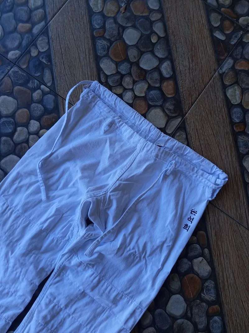 white Hook brand judo pants, which are typically designed fr photo 1